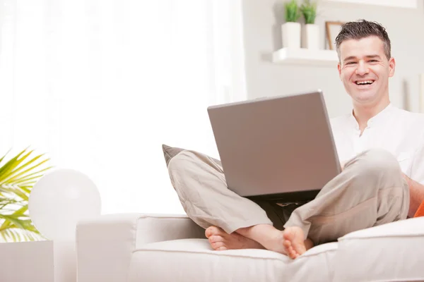 Hombre sonriendo a la cámara usando un cuaderno — Foto de Stock