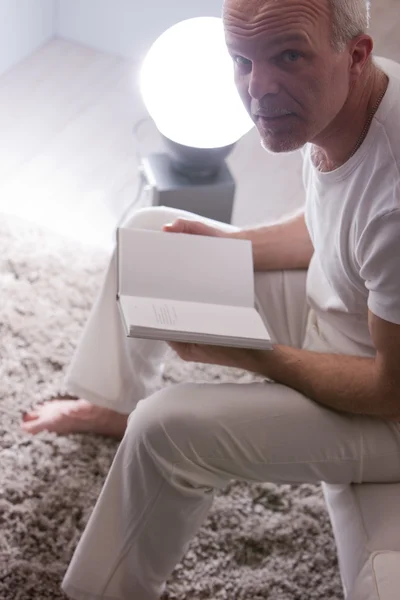 Hombre relajado leyendo un libro en casa — Foto de Stock