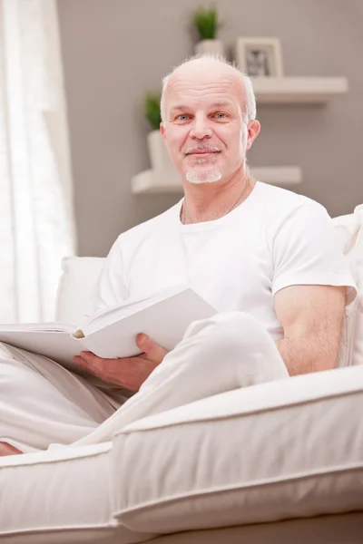 Ritratto di un uomo sorridente su un divano — Foto Stock