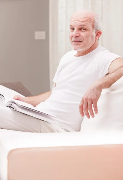 Sly smile of a man reading a book — Stock Photo, Image