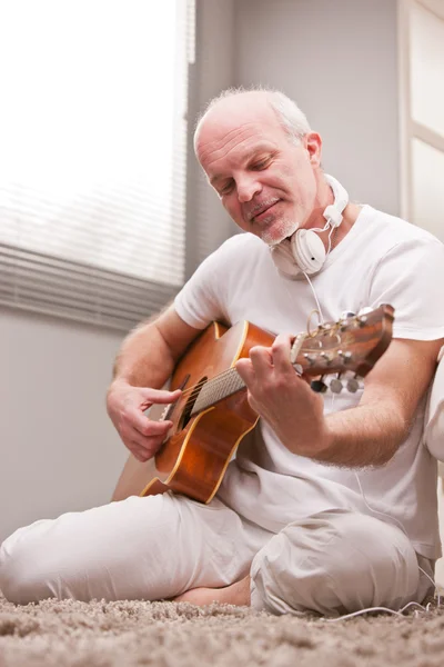 Maturo uomo suonare la chitarra a casa — Foto Stock