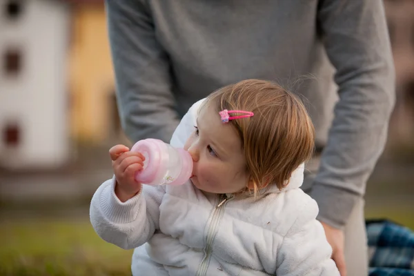 Malá dcerka sání z láhve krmení — Stock fotografie
