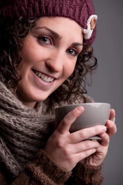 Smiling woman with a mugful of a hot drink — Stock Photo, Image