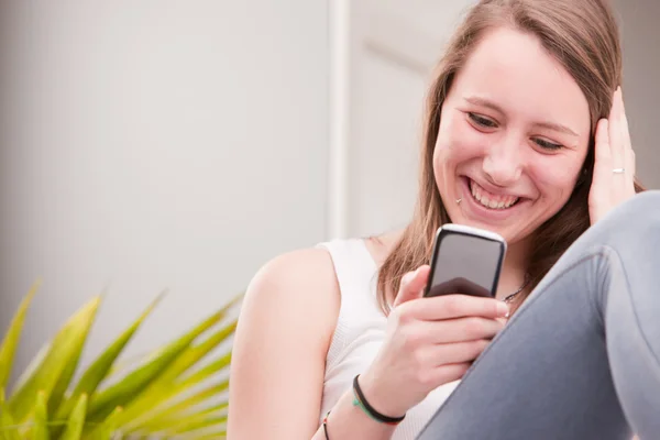 Sorridente ragazza utilizzando un telefono — Foto Stock