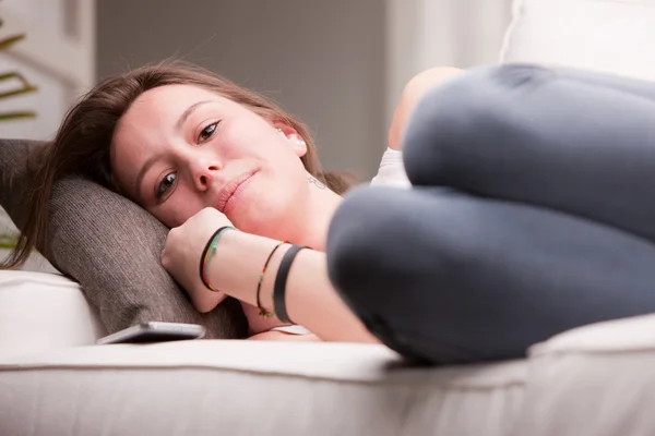 Bir kız onun kanepe yastık üzerine yoğun görünümünü — Stok fotoğraf