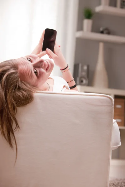 Улыбающаяся девушка с помощью телефона — стоковое фото