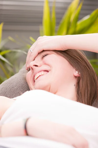 Very happy girl laughter on a sofa Stock Image