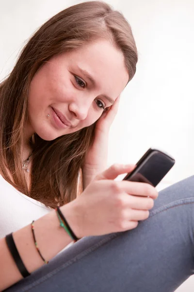 Jong meisje gericht op texting met mobiele — Stockfoto