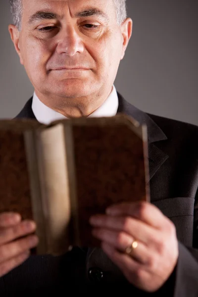 Зрелый человек, читающий древнюю книгу — стоковое фото