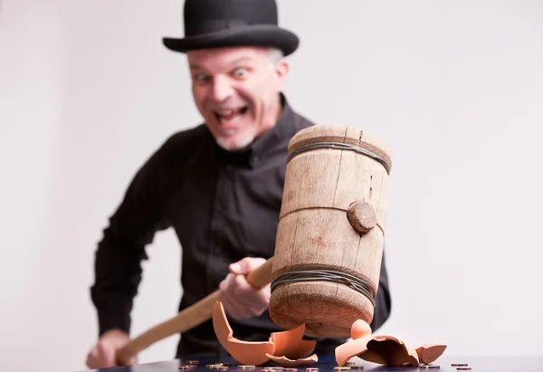Madcap laughs with big hammer on money — Stock Photo, Image