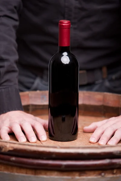 Bottle of red wine and hands of a man — Stock Photo, Image