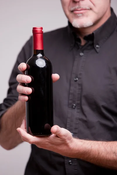 Bottle of red wine and hands of a man — Stock Photo, Image