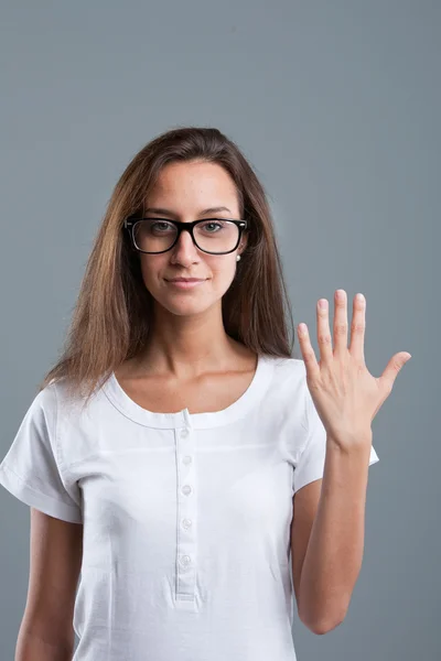Όμορφη κοπέλα που δείχνουν αριθμό πέντε με τα δάχτυλα του ενός χεριού — Φωτογραφία Αρχείου