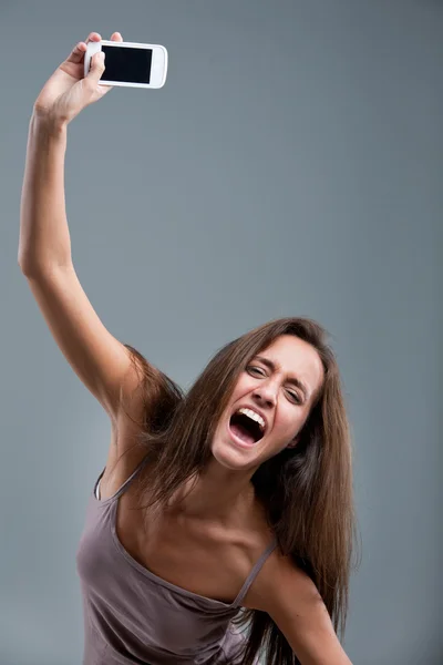 Mujer lanzando un teléfono móvil — Foto de Stock