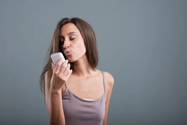 Förtjust kvinna skickar kyssar via telefon — Stockfoto