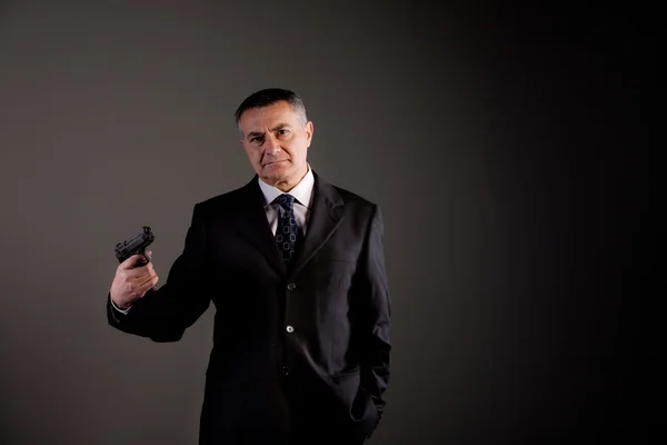 Gefährlicher Mann in Schwarz und mit Waffe — Stockfoto