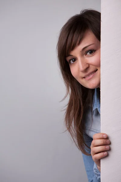 Head of a woman showing up behind the wall — Stock Photo, Image