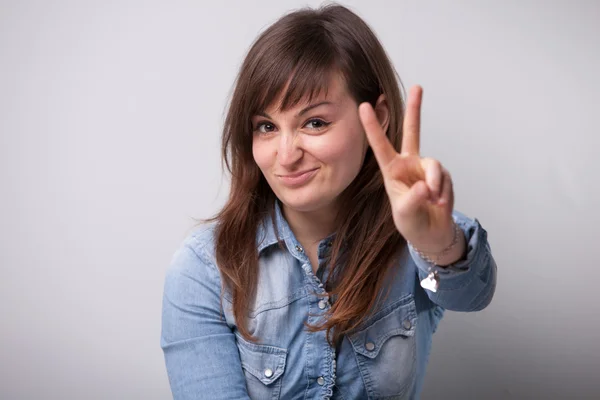 Улыбающаяся женщина победный жест пальцами — стоковое фото