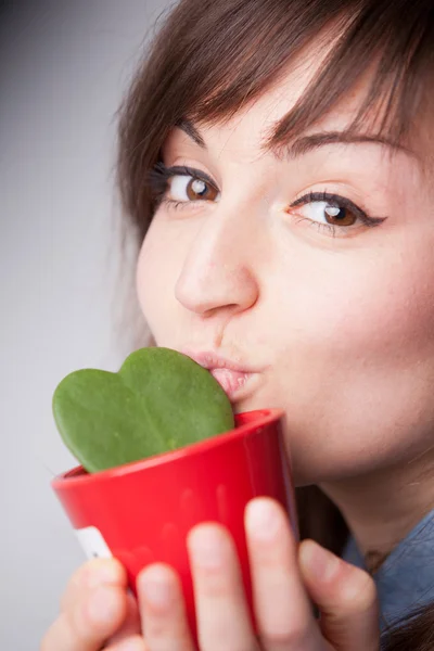 Прекрасная женщина целует маленькое растение — стоковое фото