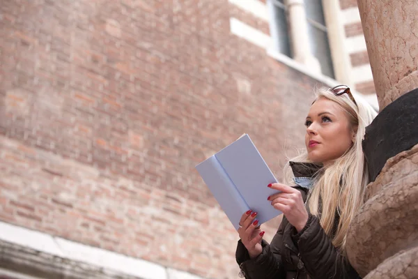 Bionda giovane donna che legge un libro all'aperto — Foto Stock