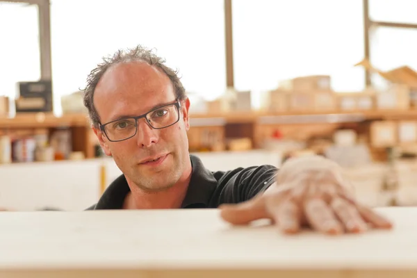 Smiling carpenter in his joiner's workshop — Stock Photo, Image