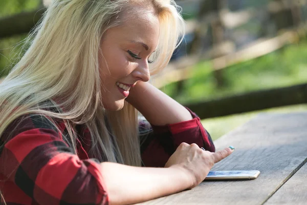 Kvinnan tittar in i skärmen på telefon — Stockfoto