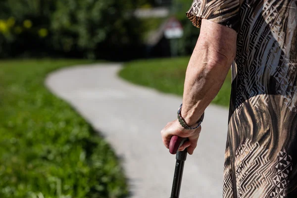 Aged woman walking with her stick — Stock Photo, Image