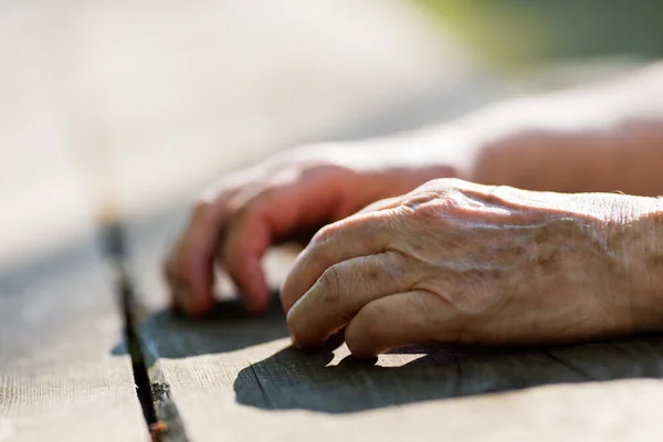 aged hands of an old person on a table