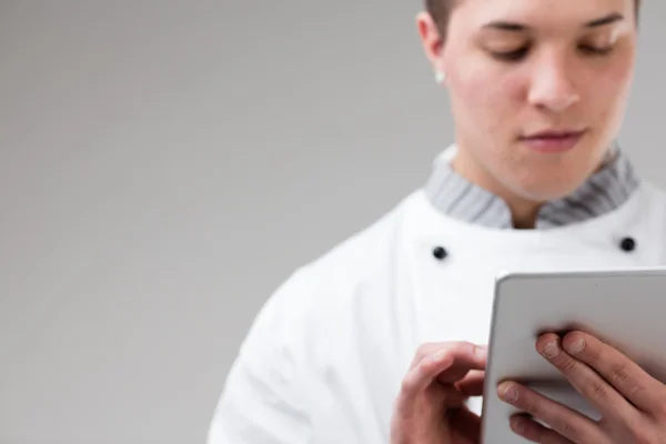 Young chef ordering online with his tablet — Stock Photo, Image