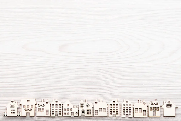 Piccolo villaggio di figure di legno casa allineati su una superficie in w — Foto Stock