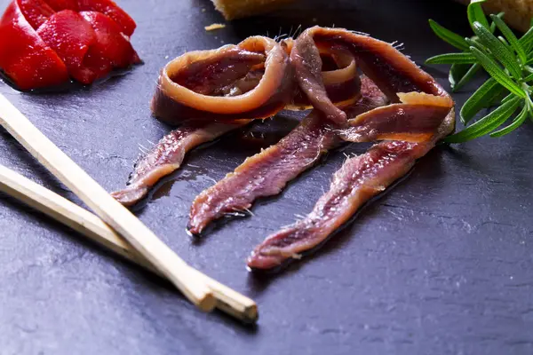 Anchovies with chopsticks on board — Stock Photo, Image