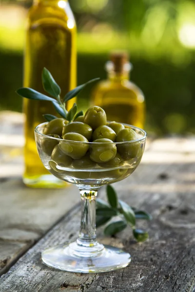 Стакан полный оливок с зеленым фоном — стоковое фото