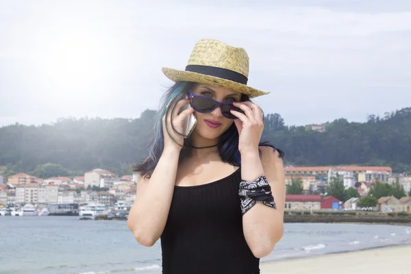 Vrouw met mobiele telefoon op het strand — Stockfoto