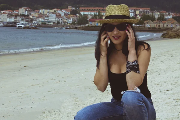 Vrouw met mobiele telefoon op het strand — Stockfoto