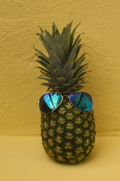 Pineapple with sunglasses on yellow background — Stock Photo, Image