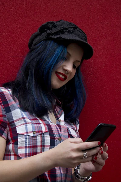빨간 벽에 휴대 전화와 함께 hipster 여자 — 스톡 사진