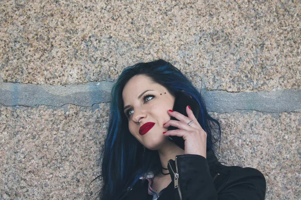 Jeune femme avec téléphone portable dans la rue — Photo