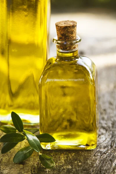 Bottiglie di olio d'oliva su legno con fondo verde — Foto Stock