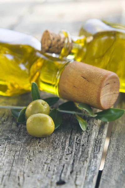 Frascos de aceite de oliva y aceitunas sobre mesa vintage — Foto de Stock