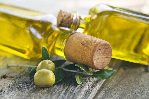 Frascos de aceite de oliva y aceitunas sobre mesa vintage — Foto de Stock