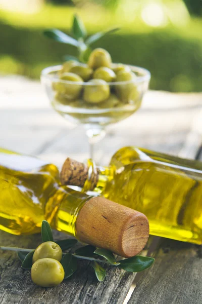 Frascos de aceite de oliva y aceitunas sobre mesa vintage — Foto de Stock