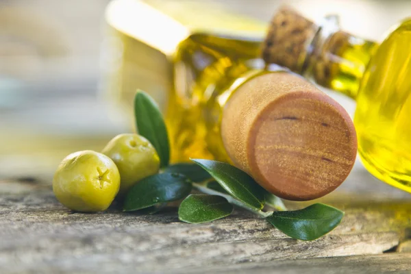 Frascos de aceite de oliva y aceitunas sobre mesa vintage — Foto de Stock