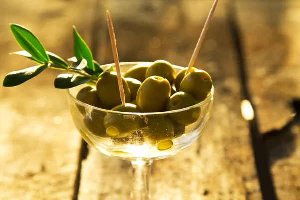 Glass cup green olives stuffed with background field — Stock Photo, Image