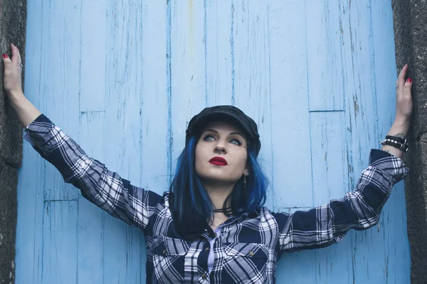 Девушка-хипстер на голубой стене — стоковое фото