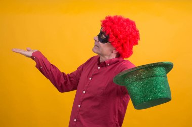 Siyah maskeli, peruklu ve şapkalı gülümseyen adam, mutlu karnaval konsepti.