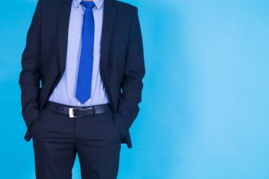 Takım elbiseli adam elleri cebinde.