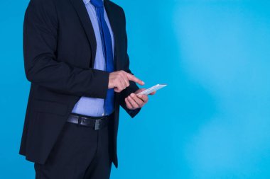 Mavi arka planda cep telefonu kullanan iş adamı