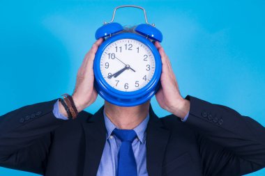 Yüzünde çalar saat tutan bir işadamı.