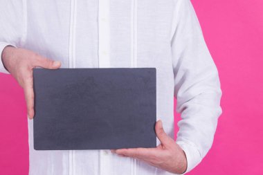 Pembe arka planda boş poster tutan adam