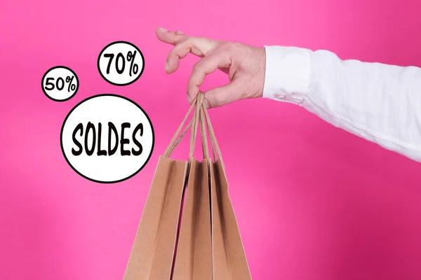 man with bags in hand with sale and discounts text, concept of shopping and sales